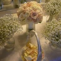 Elegant floral centerpiece with pale roses and baby's breath on a decorated table