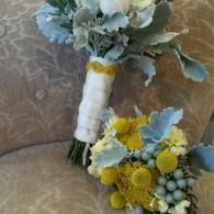 Two floral bouquets with blue, white, and yellow flowers on a beige patterned chair