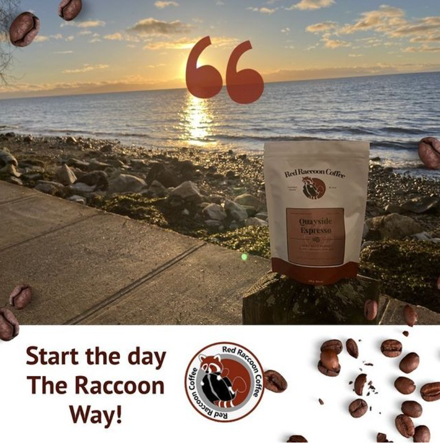 A bag of coffee sits on a sidewalk next to the ocean