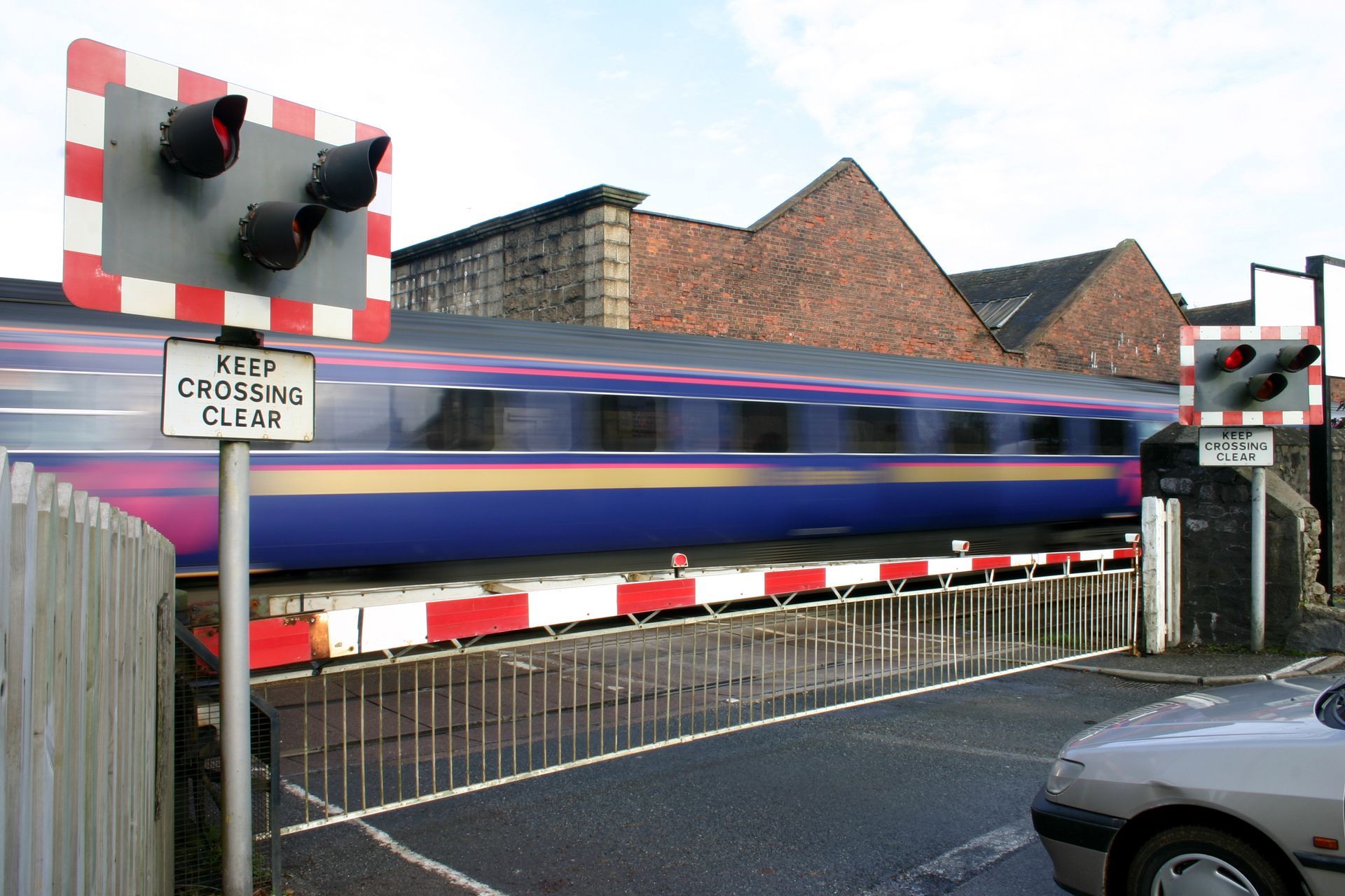 A train crossing a railroad crossing with a sign that says keep crossing clear