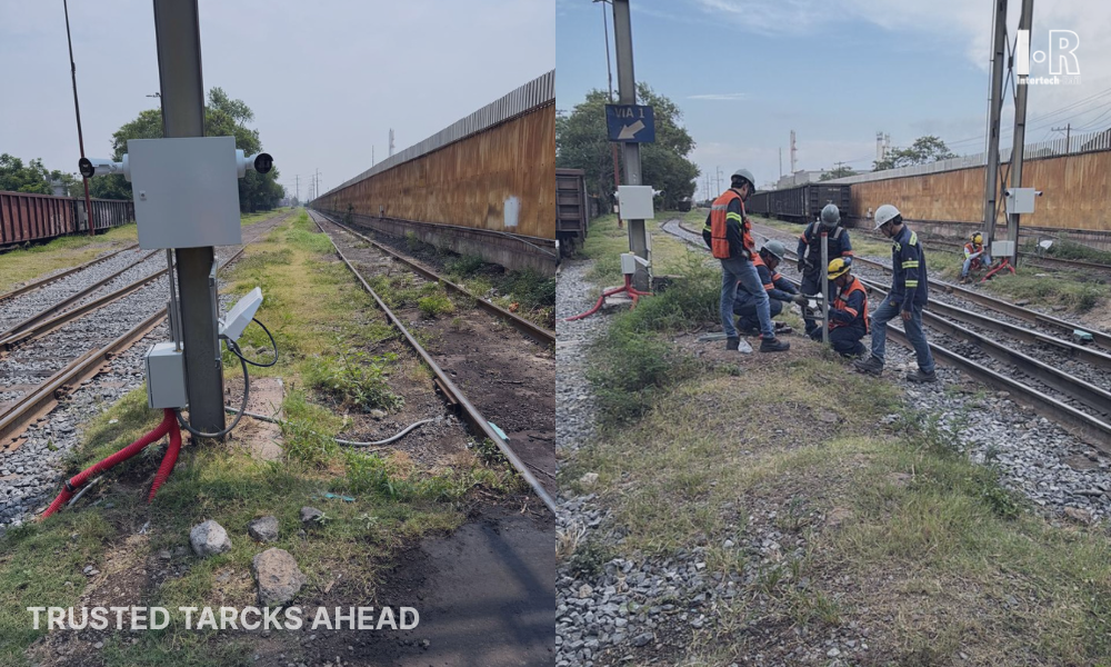 Railway tracks beside a road, with workers in safety gear inspecting the rail crossing.