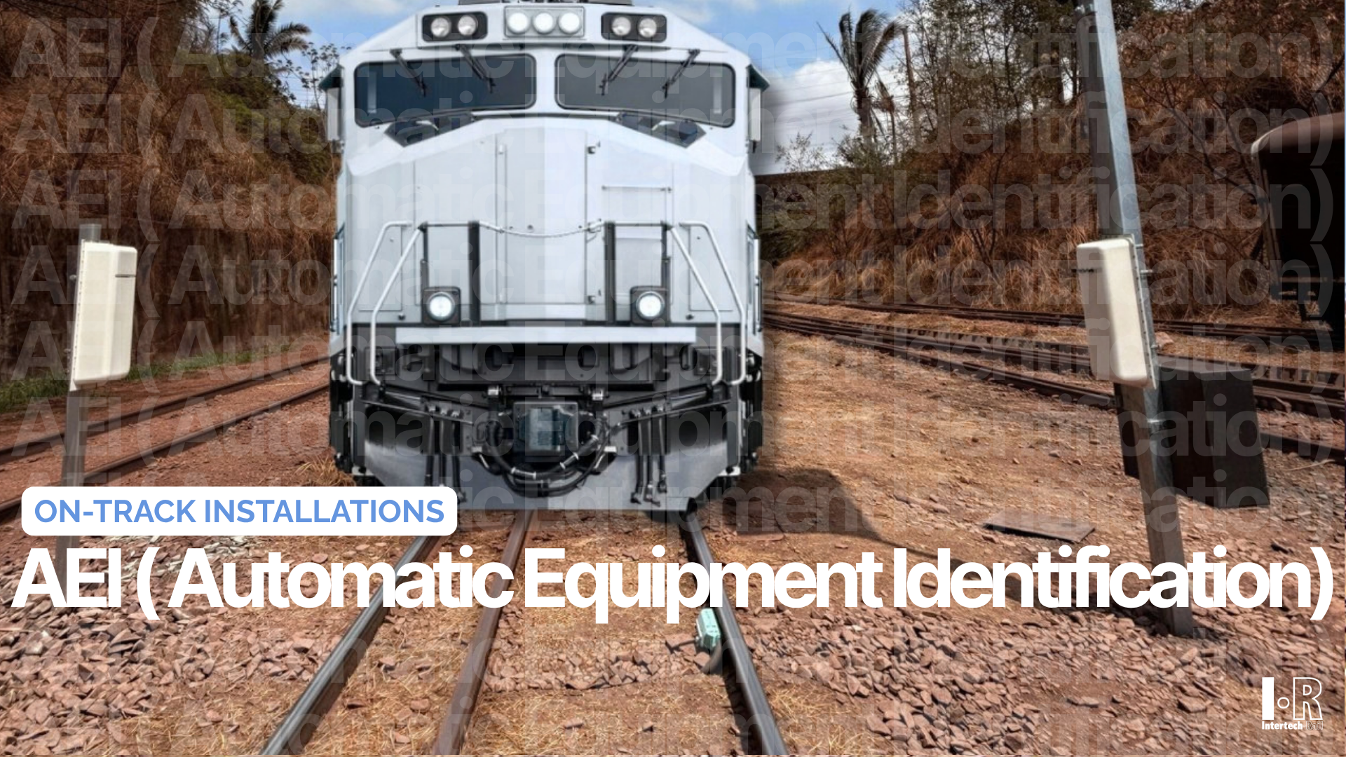 Front view of a white locomotive on tracks in a rail yard, labeled “AEI (Automatic Equipment Identification).”