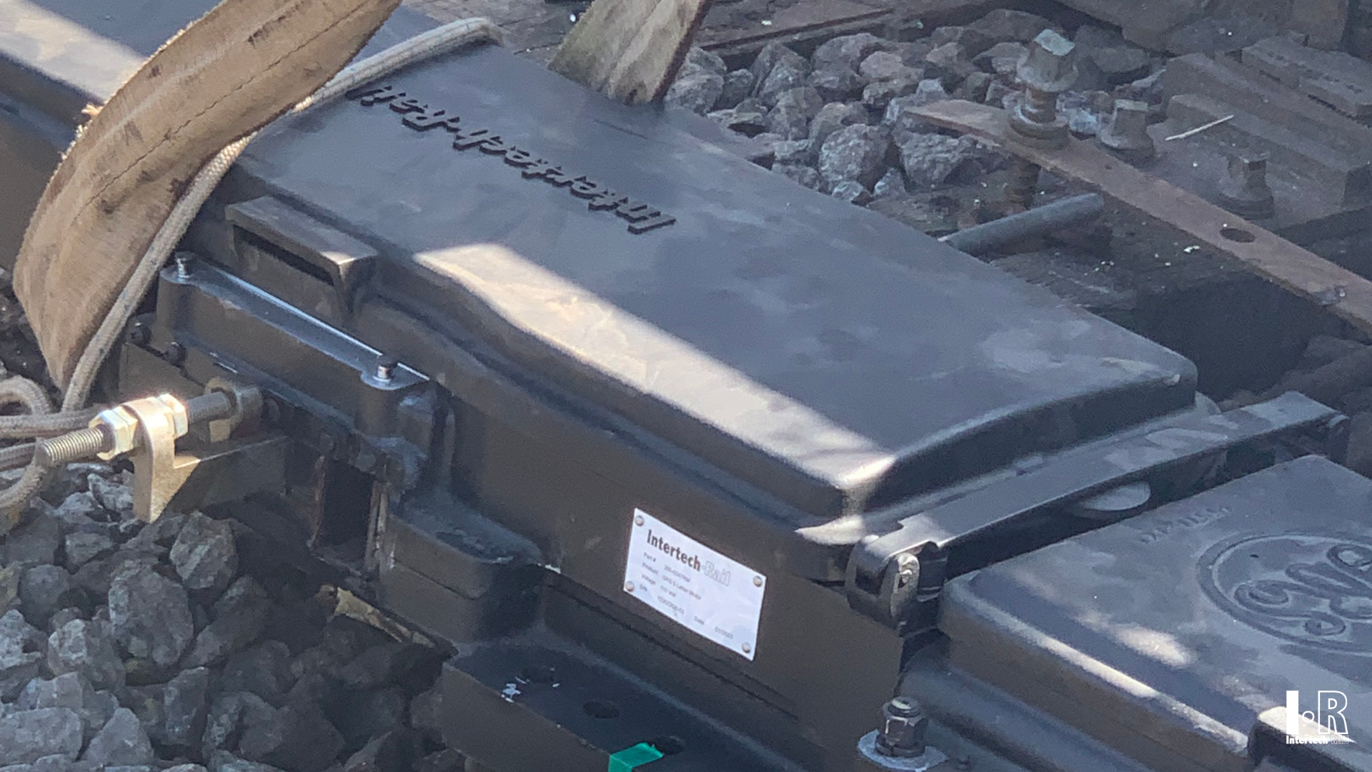 IR5G switch machine by Intertech Rail resting on dark rocks 