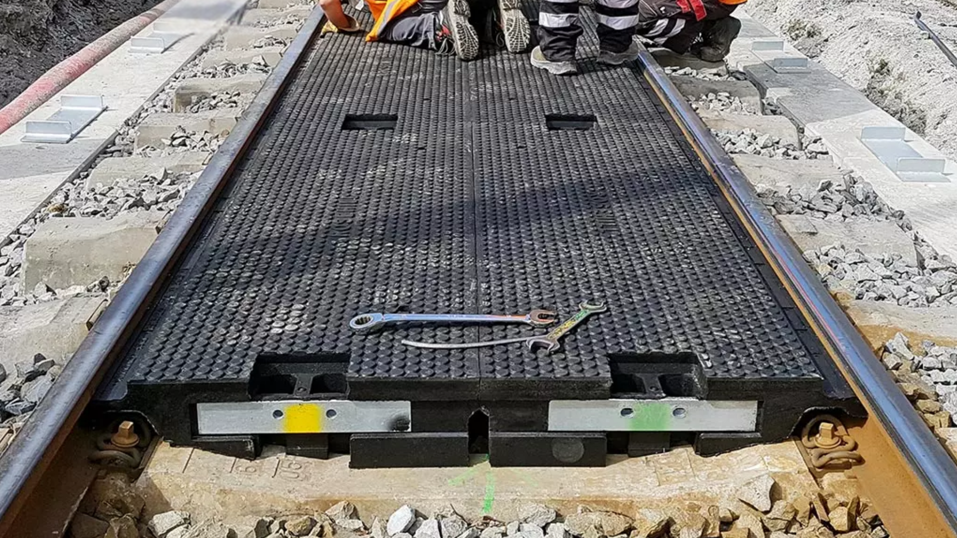 Construction workers installing black drainage mat railway level crossing installation-  Intertech Rail