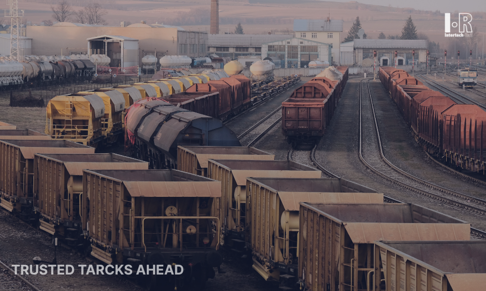 Rail yard with rows of freight cars on multiple tracks under a cloudy sky