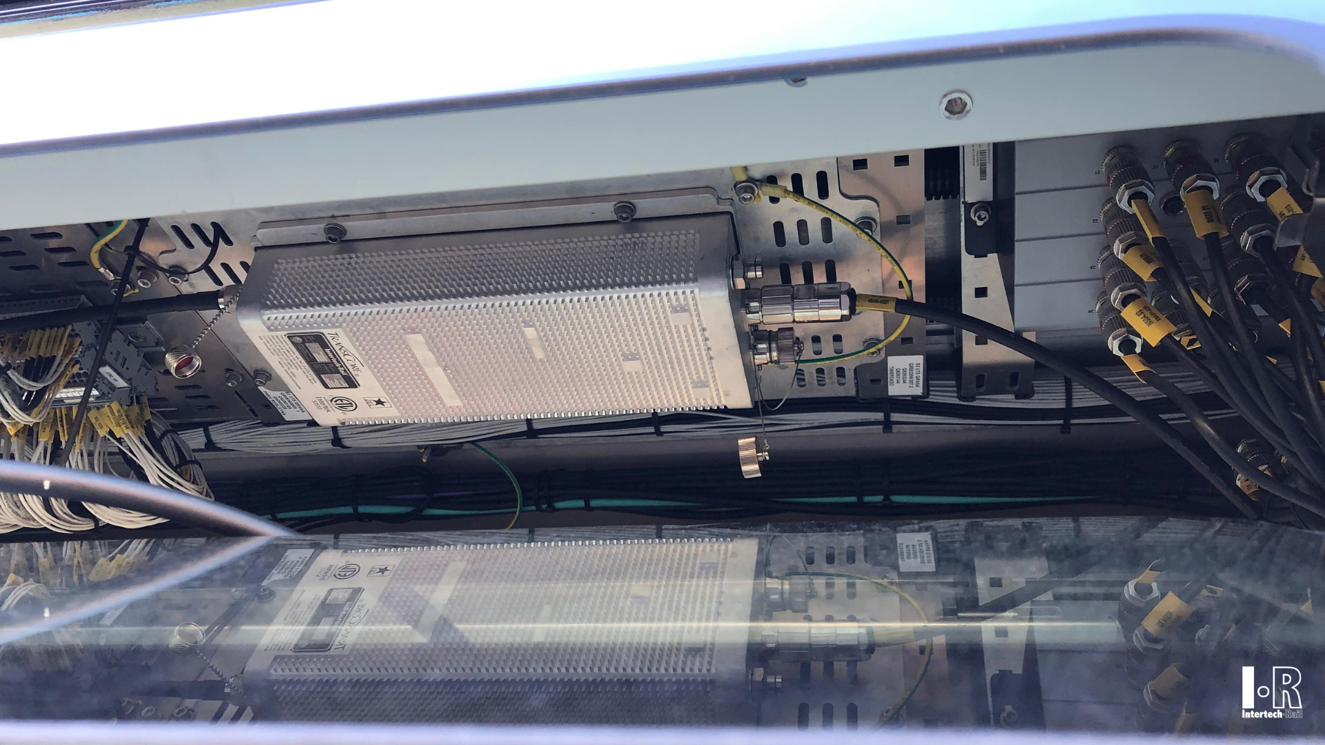 Close-up of computer hardware inside a transparent case, showing circuit boards and cables. Balise System