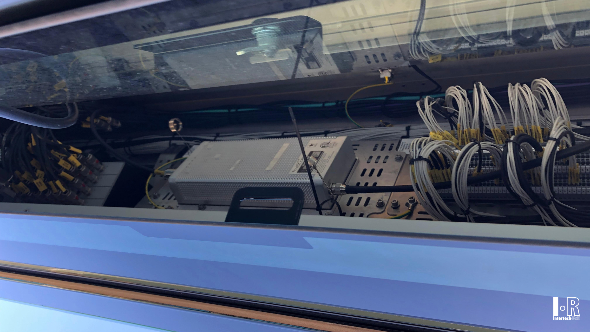 Close-up of a bus windshield showing dashboard controls and cable bundles inside the front cabin. Balise System