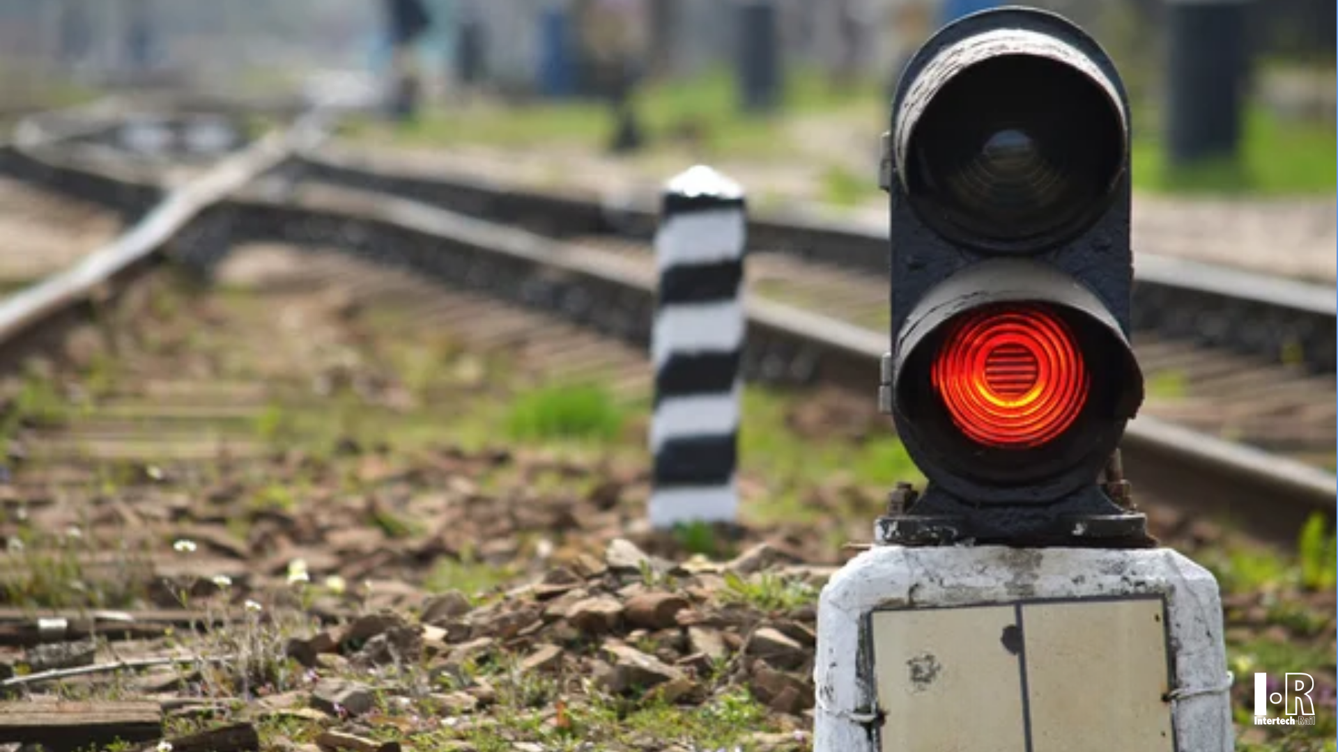 Red railway signal lit over tracks with blurred background, Two-light LED signal for railway level crossing -Intertech Rail