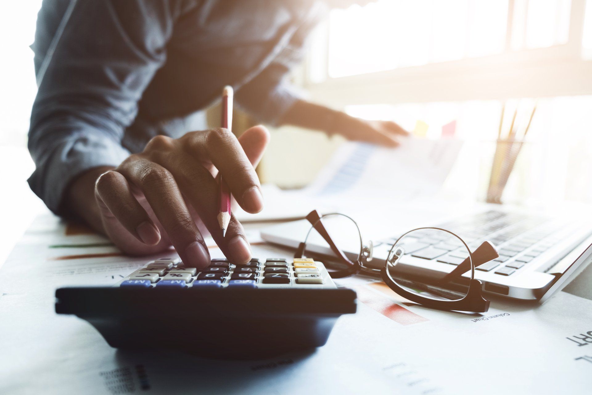 ccountant hand holding pen working on calculator to calculate business data