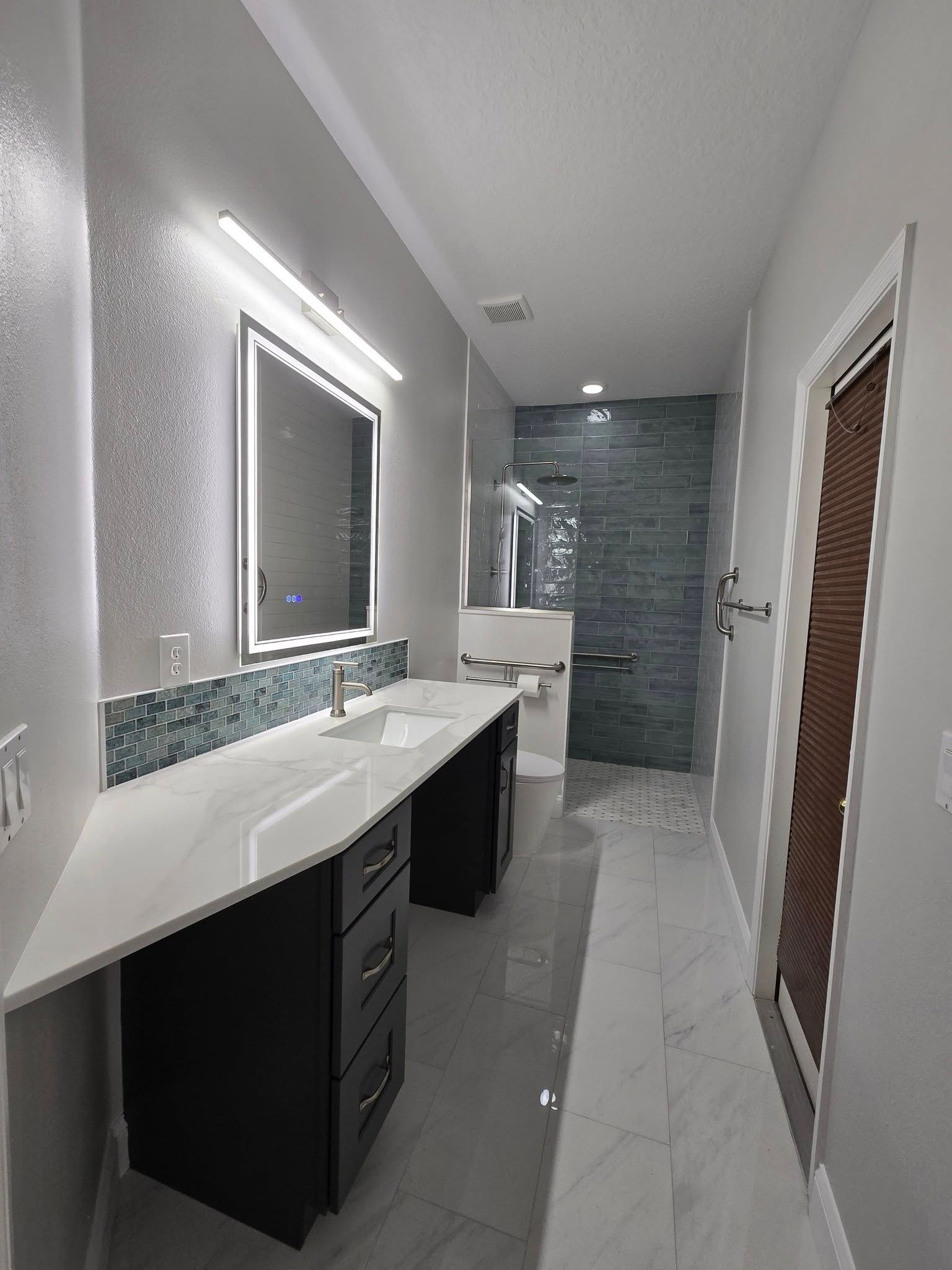 A bathroom with two sinks , a mirror and a walk in shower.