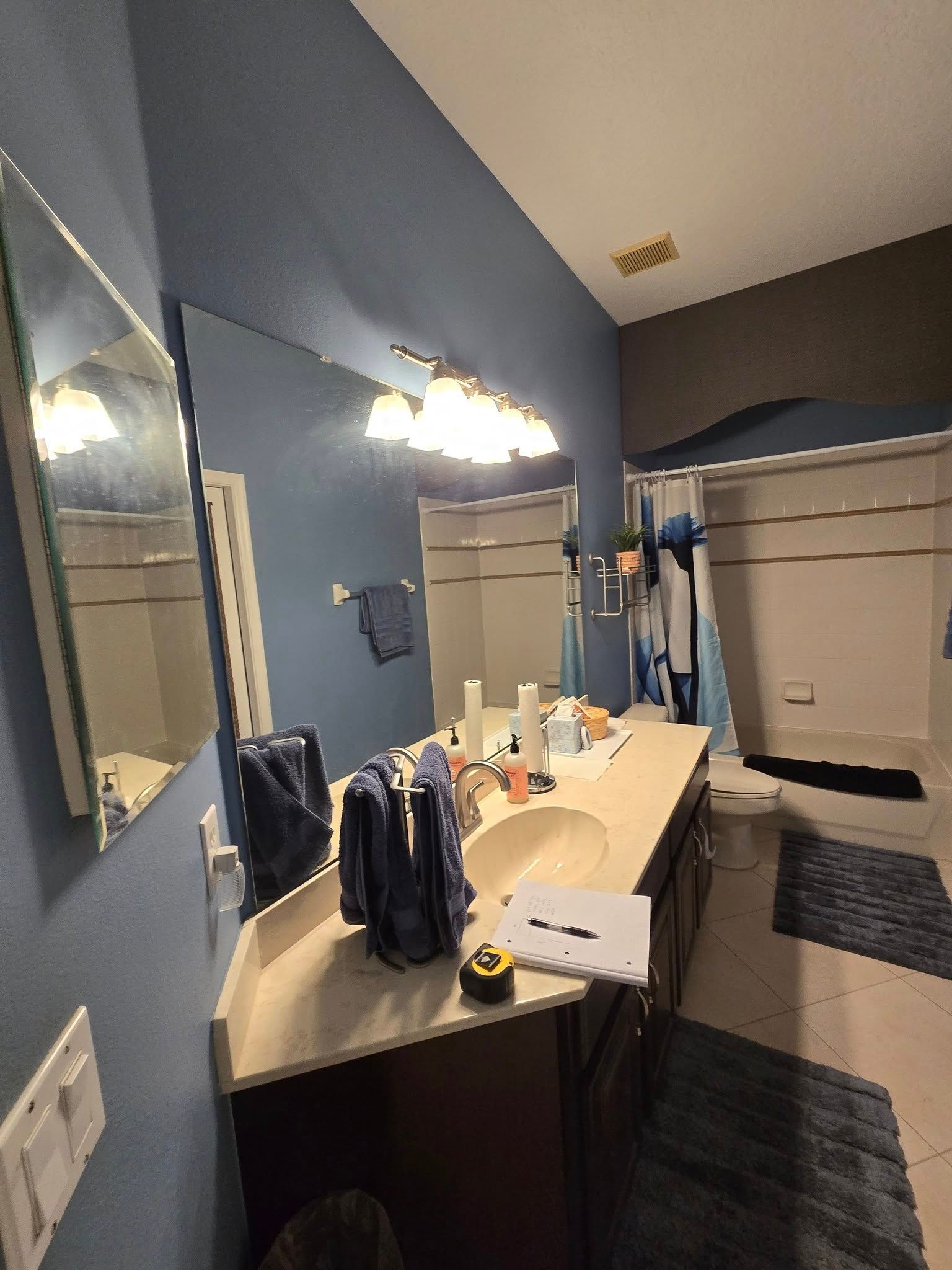A bathroom with a single sink and a builder-grade white bathtub. before picture