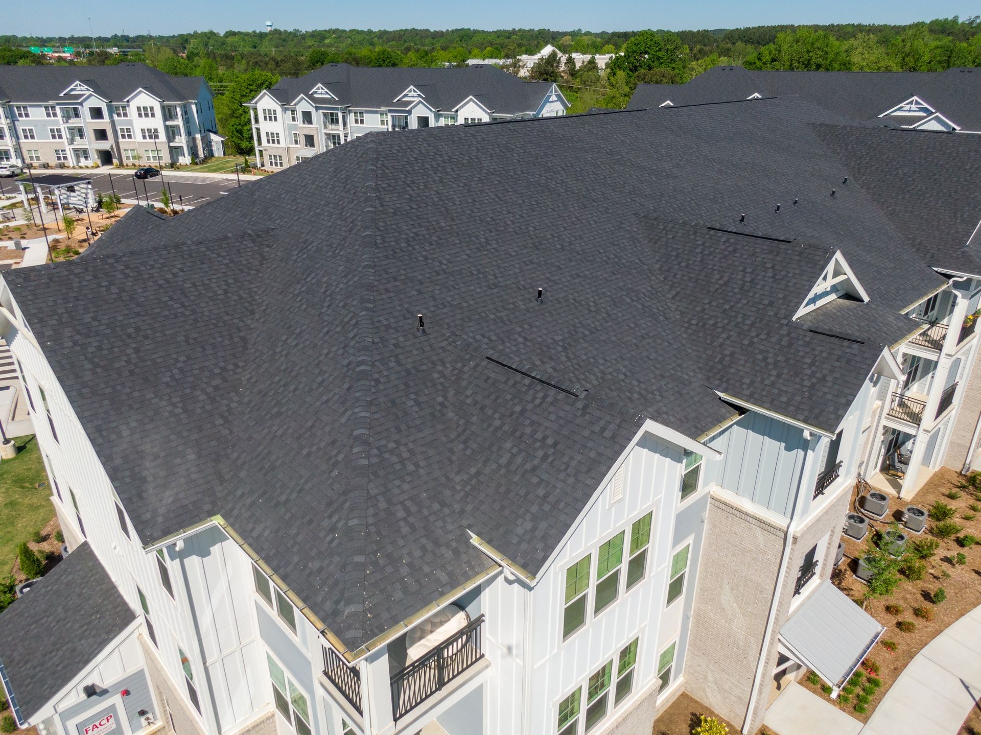 An aerial view of a large apartment building with a black roof.