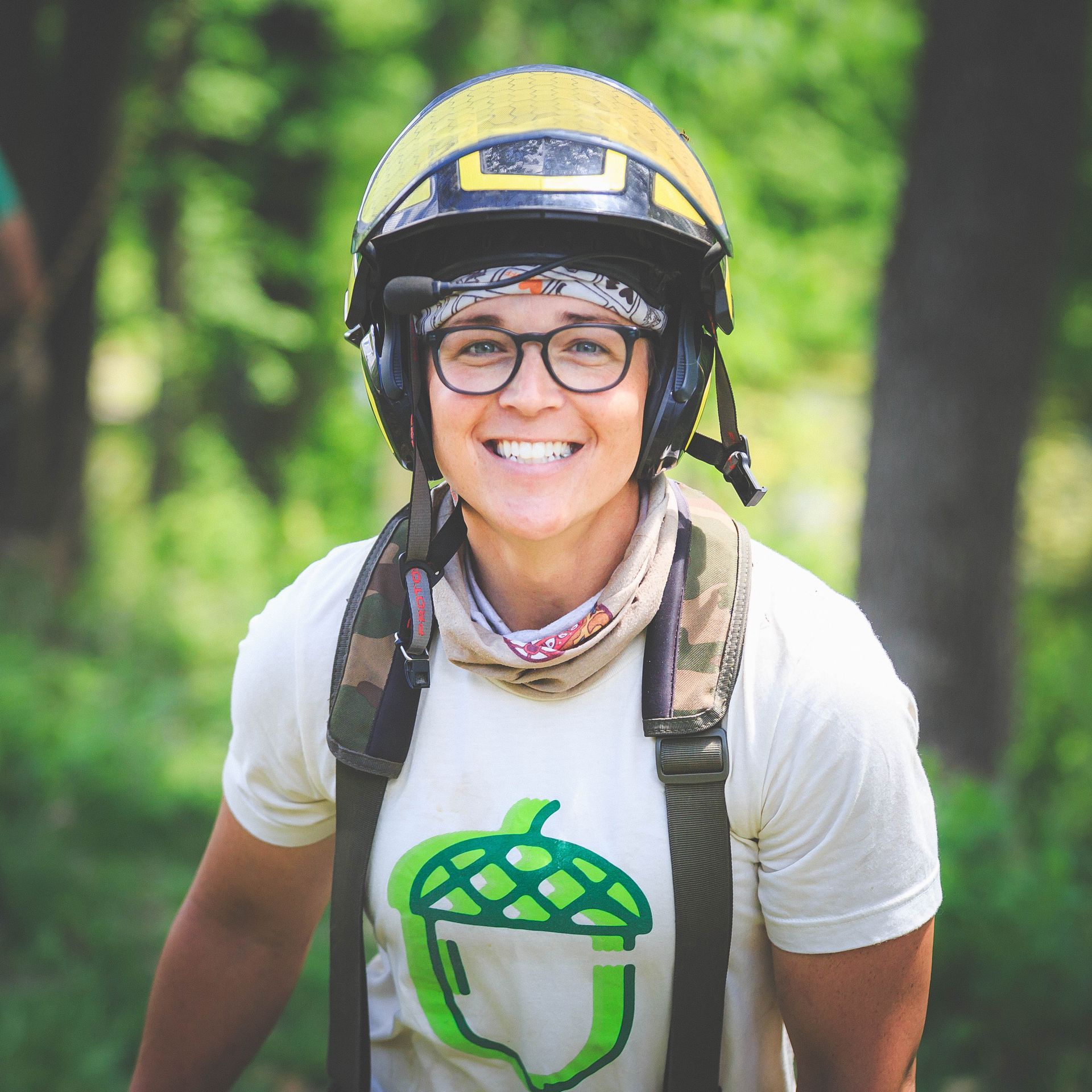 A woman wearing a helmet and a t-shirt with an acorn on it