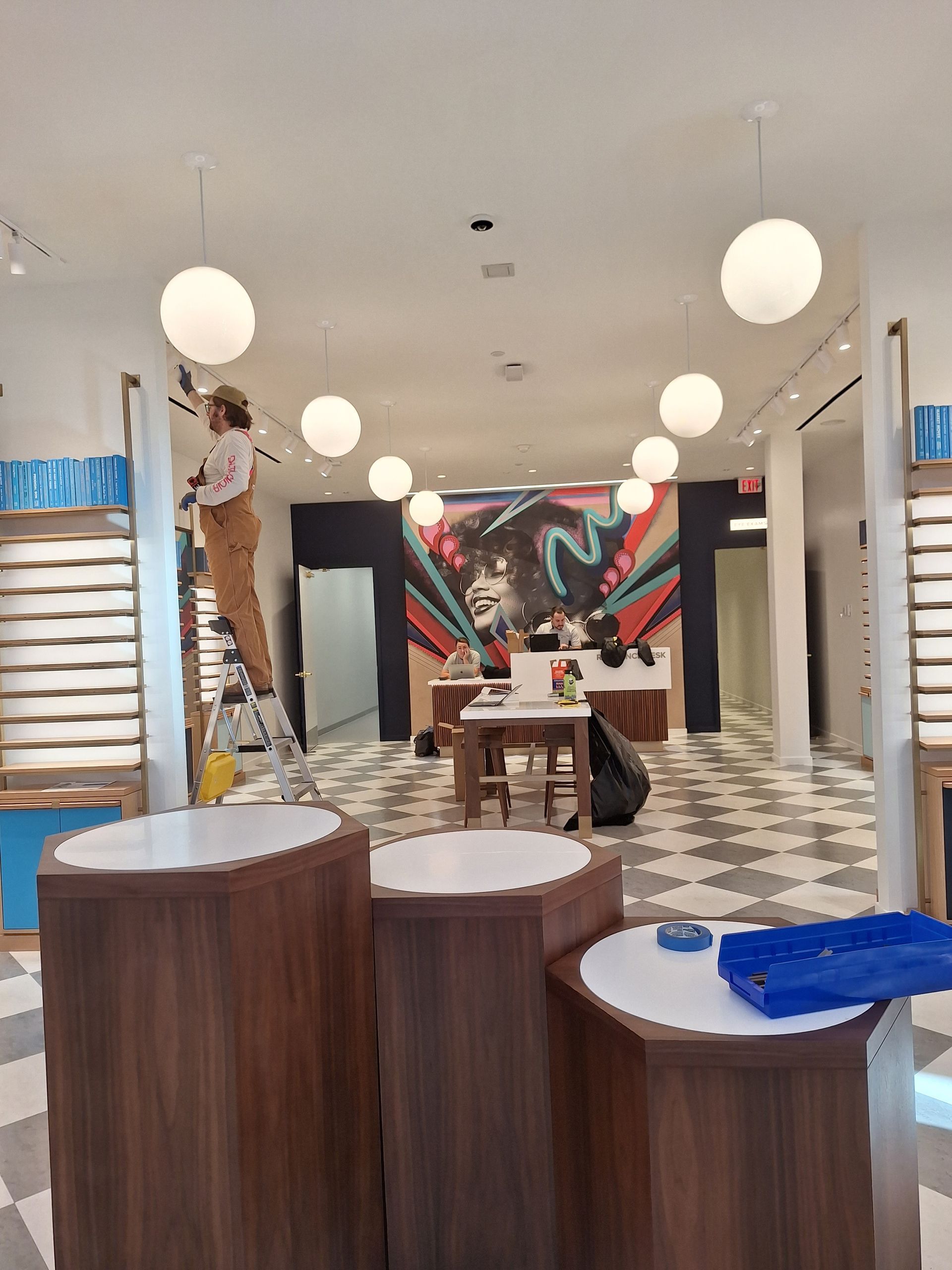 A man is painting a mural on the wall of a store.