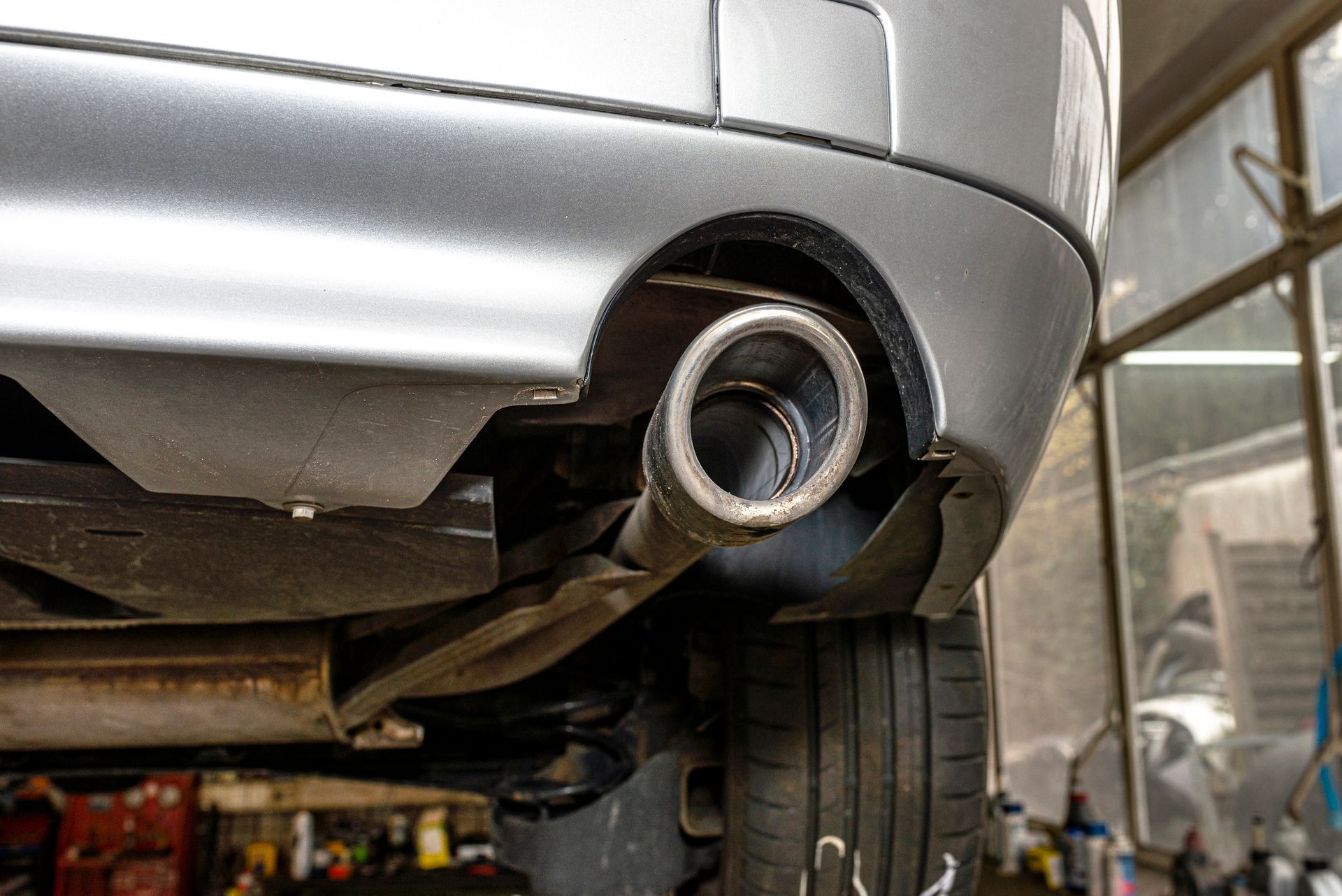 A close up of a car exhaust pipe in a garage.