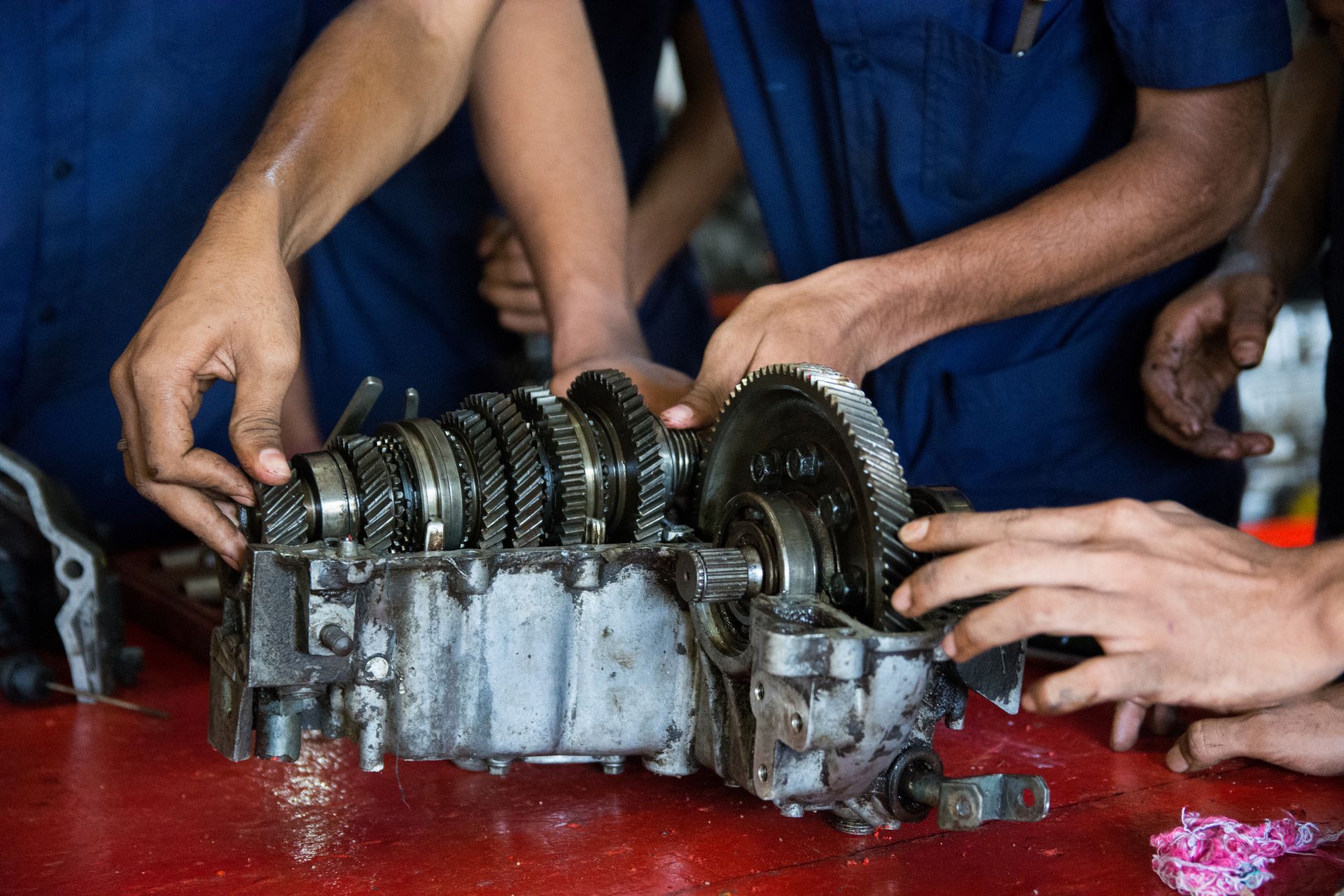 A group of mechanics are working on a transmission.