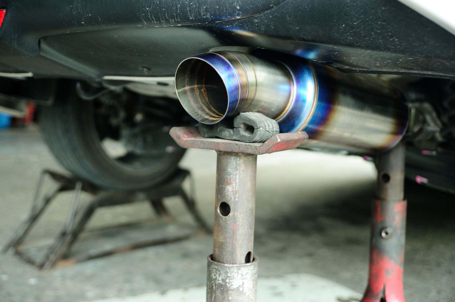 A car exhaust pipe is sitting on top of a metal stand.