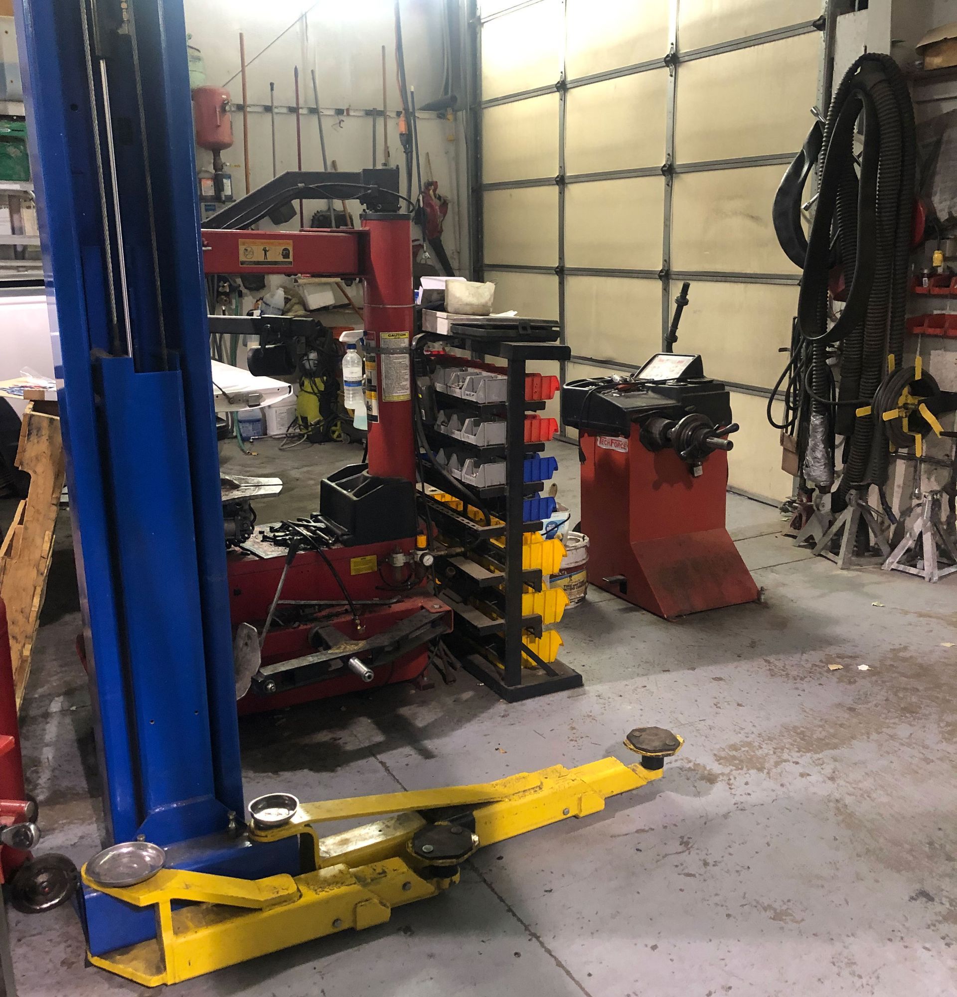 A blue and yellow lift is sitting in a garage