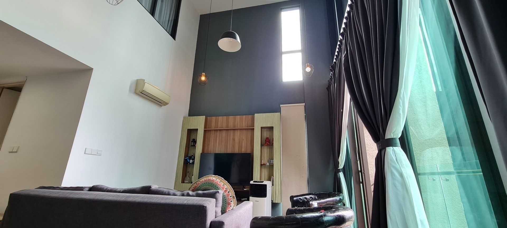 A living room with a lot of furniture and a high ceiling.