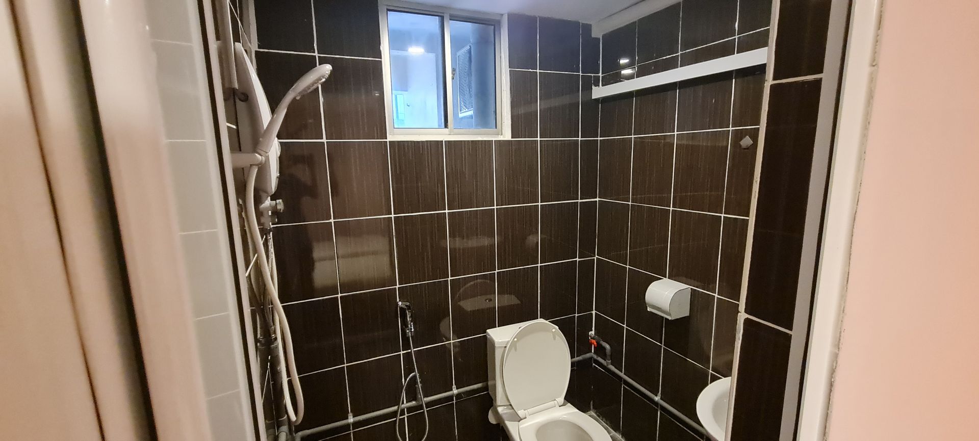 A bathroom with a toilet , sink and shower.