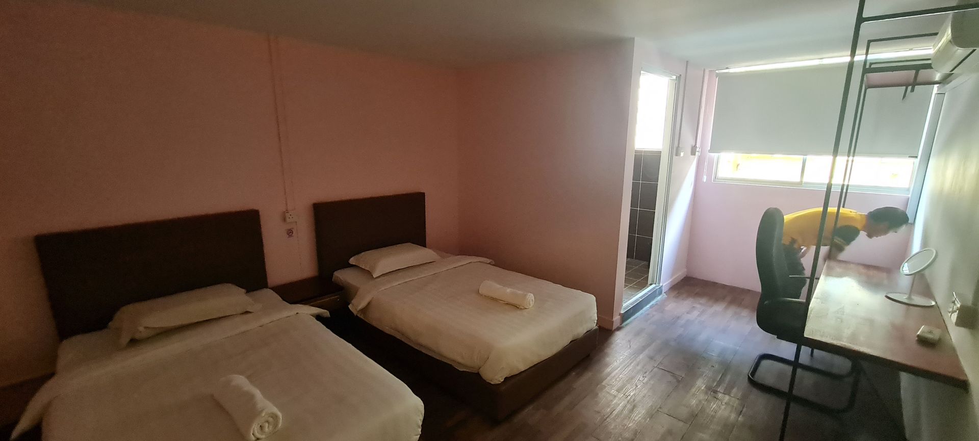 A hotel room with two beds and a desk.