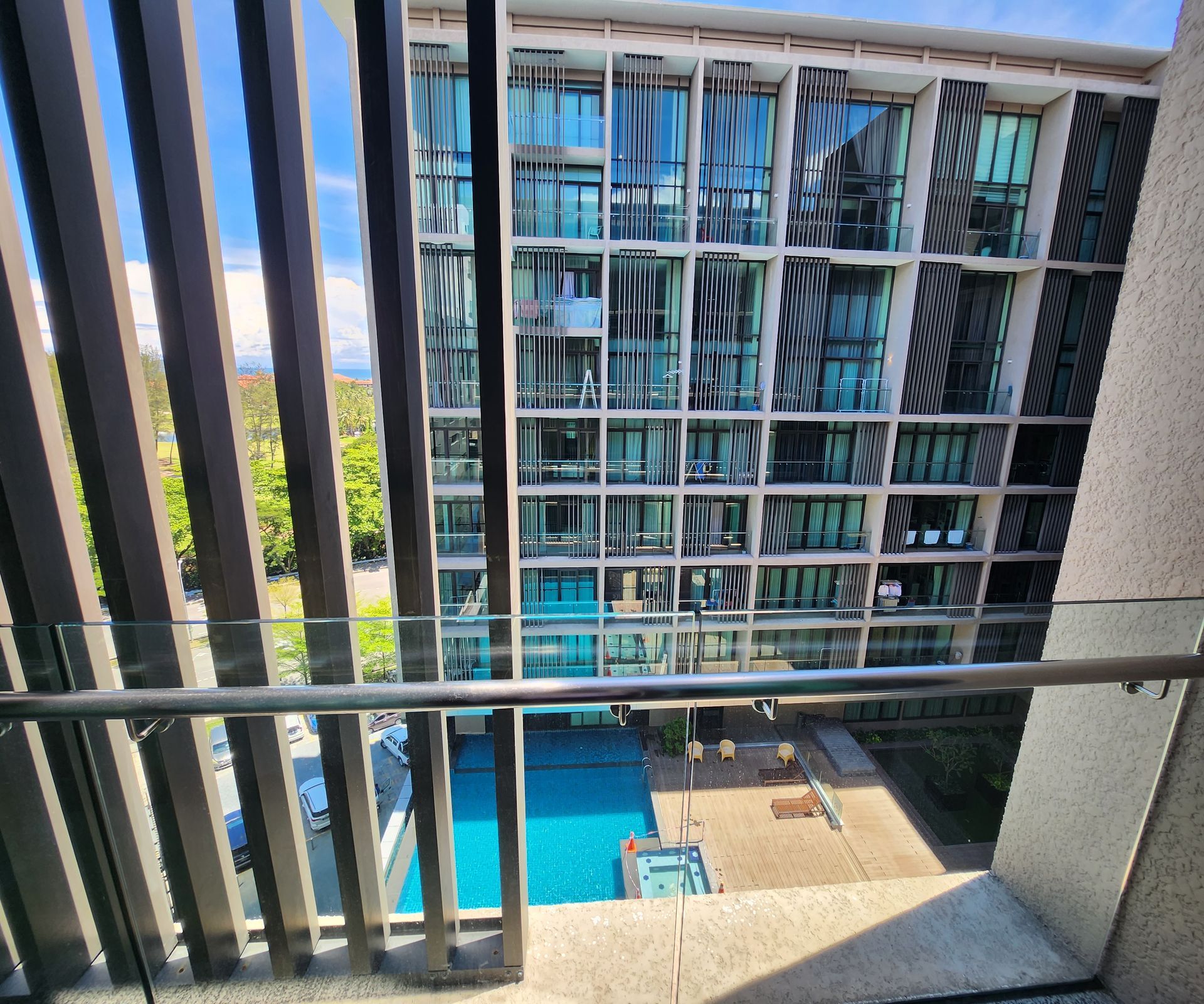 A balcony with a view of a building and a pool