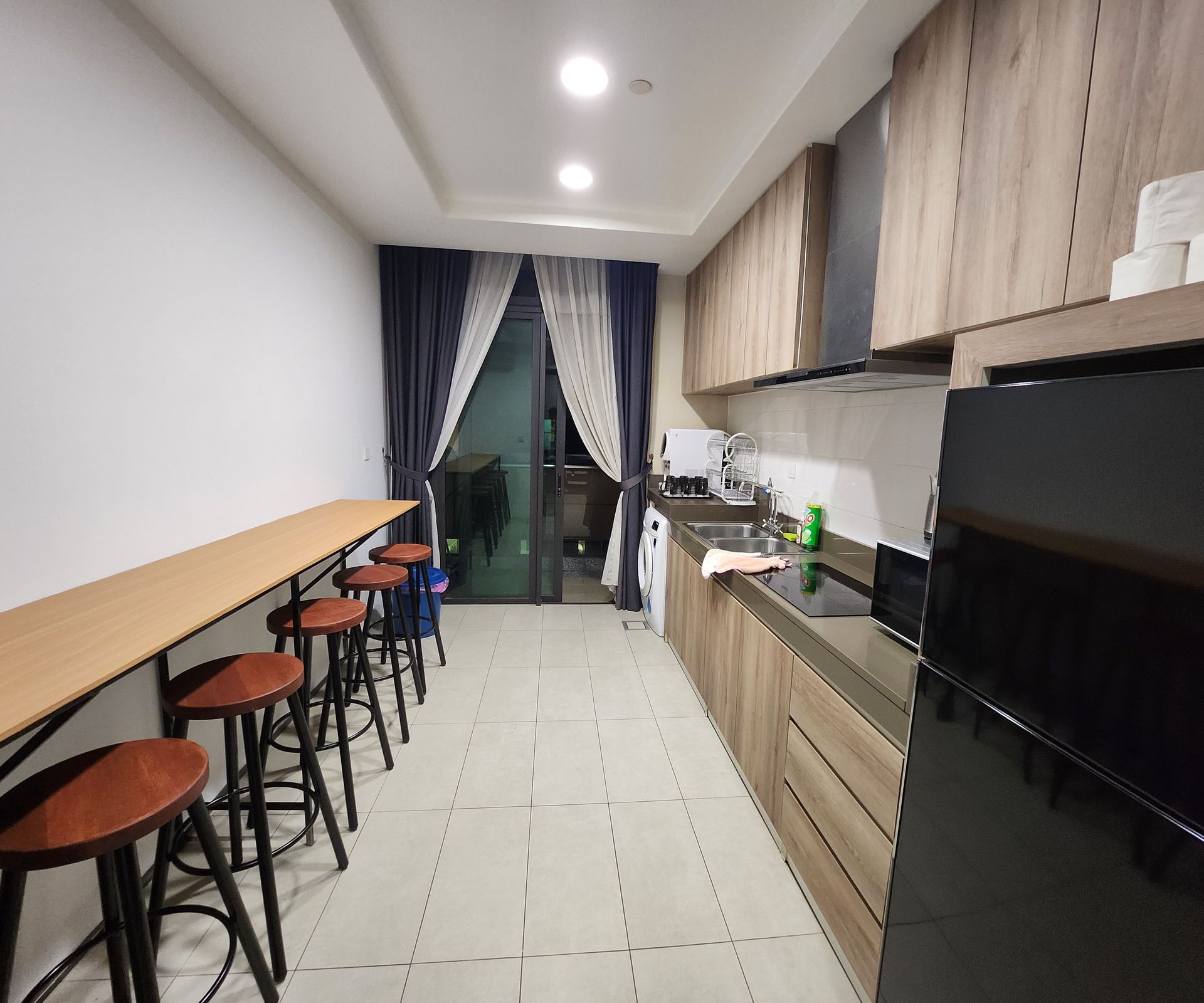 A kitchen with wooden cabinets and a black refrigerator