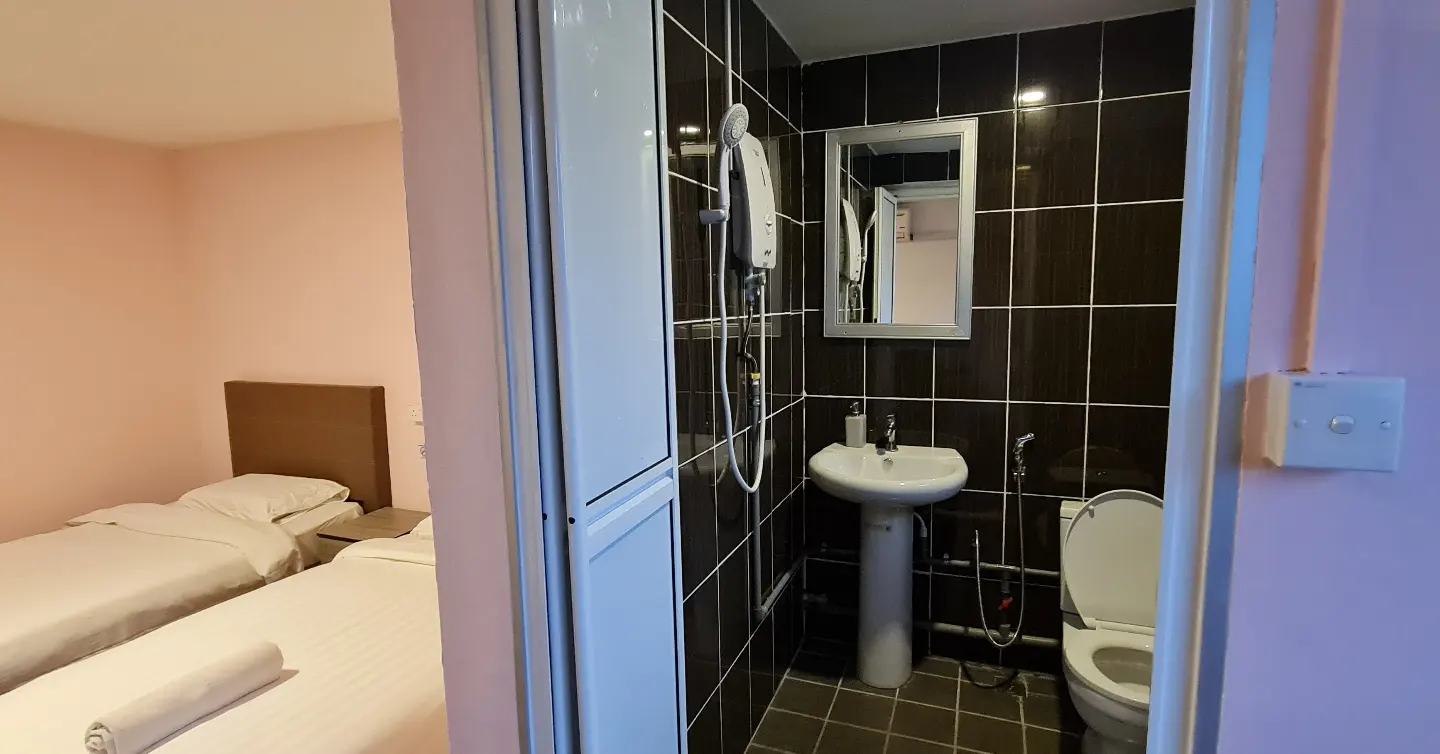 A bathroom with a sink , toilet and mirror in a hotel room.