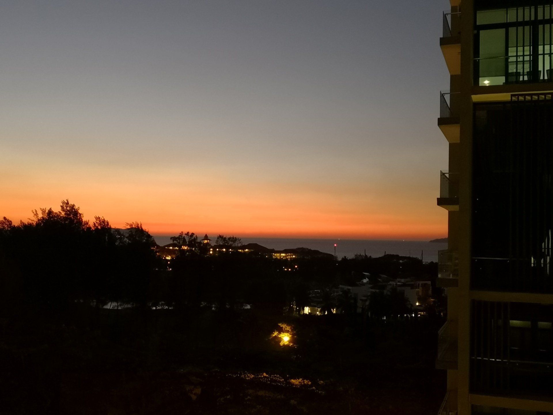 A view of a sunset from a balcony of a building.