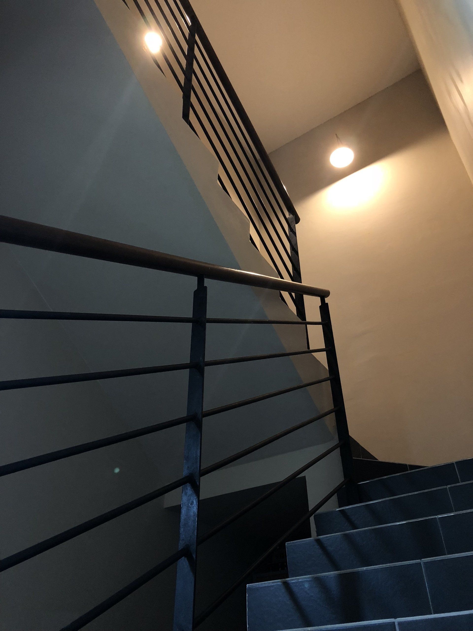 Looking up a set of stairs with a black railing