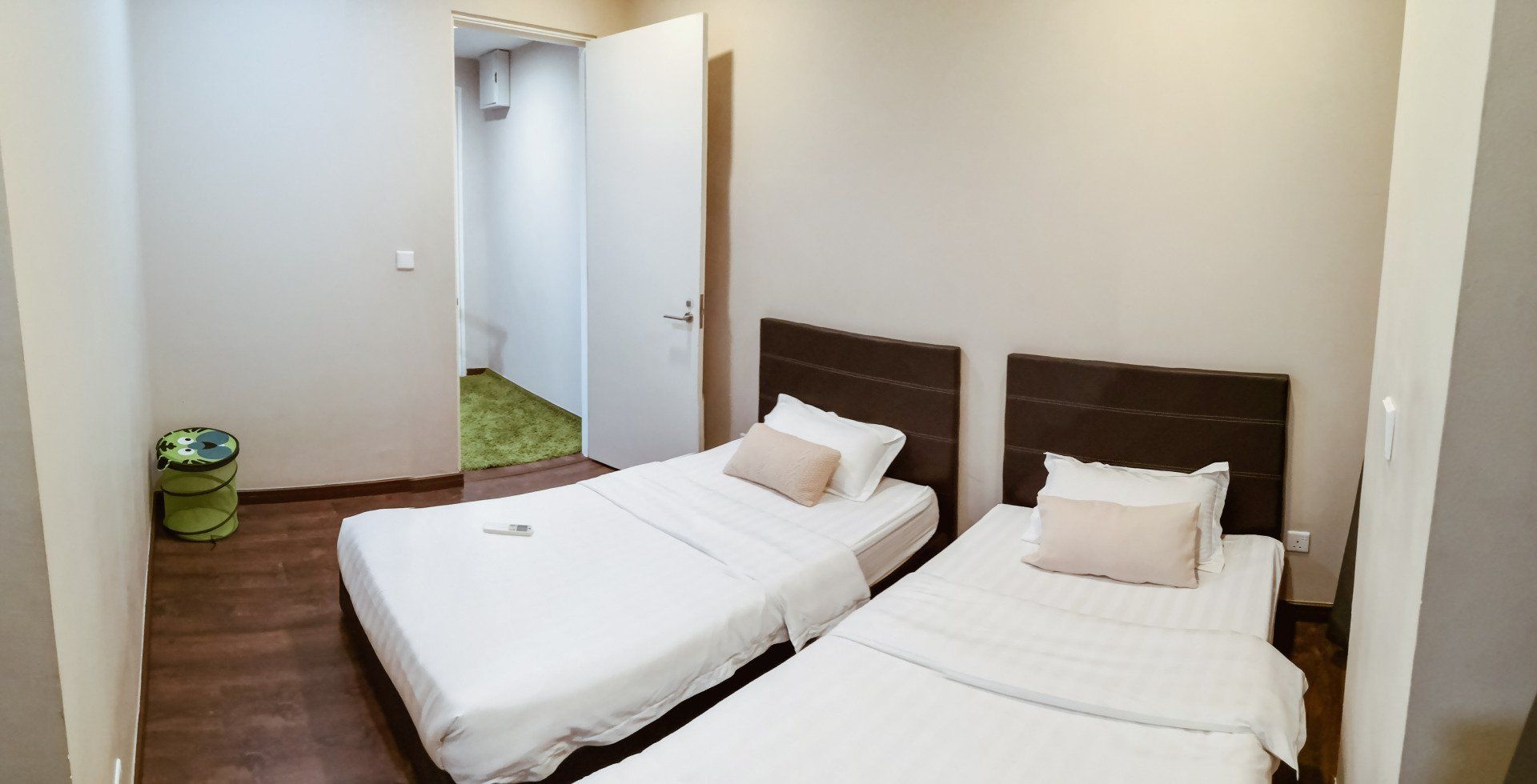 A bedroom with two beds and a door leading to a bathroom.