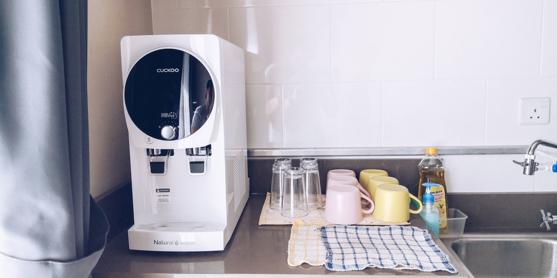 A water dispenser is sitting on a counter next to a sink.