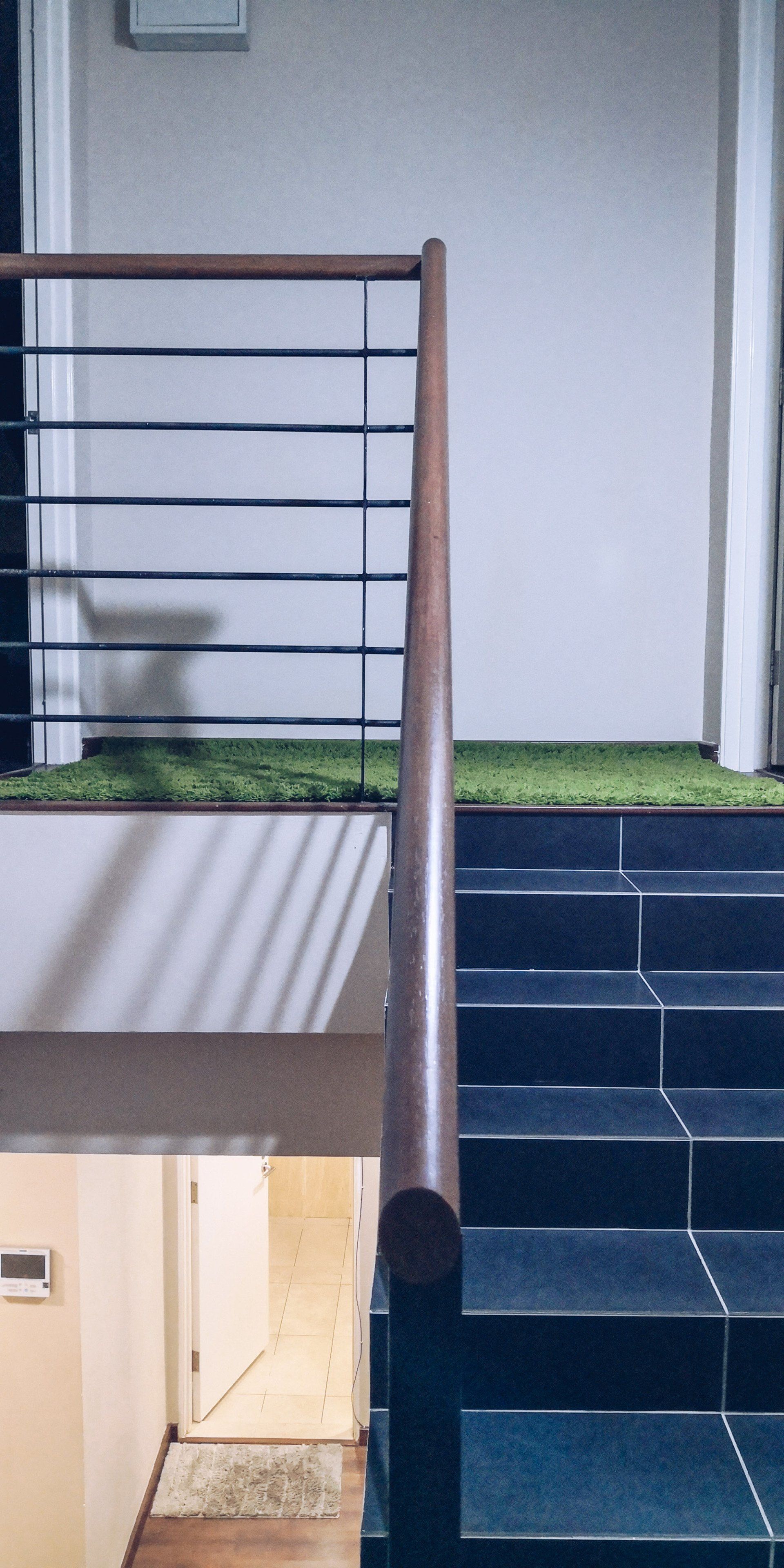 A staircase with a wooden railing leading up to the second floor