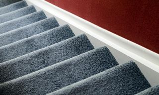 Un gros plan d'un escalier avec un mur rouge en arrière-plan