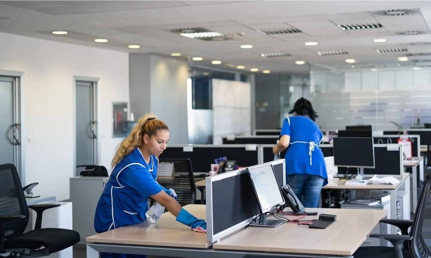Une femme nettoie un bureau dans un bureau.