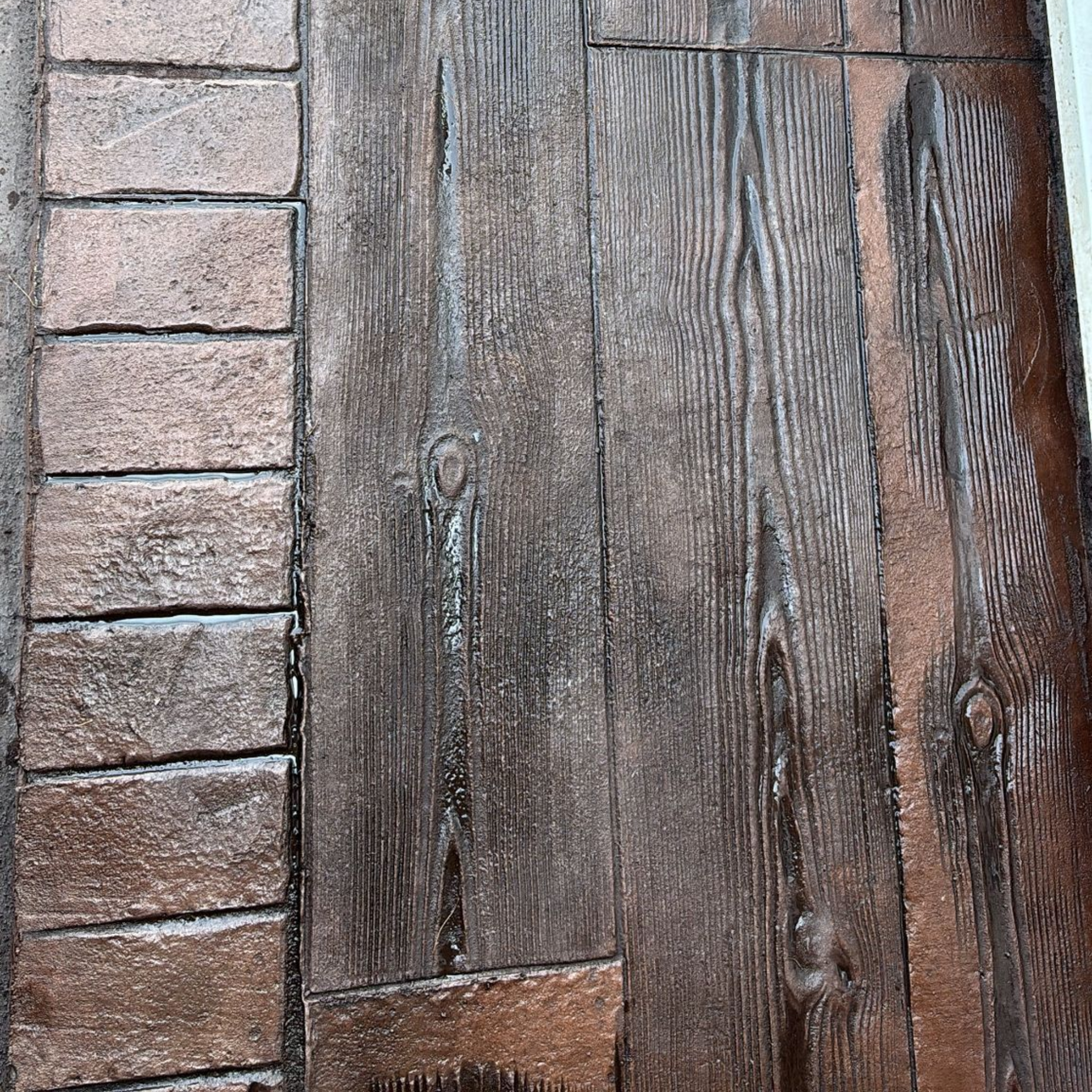 Close-up of weathered wooden planks beside a row of pink bricks.