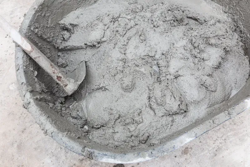 Bucket of wet gray cement with a trowel in it