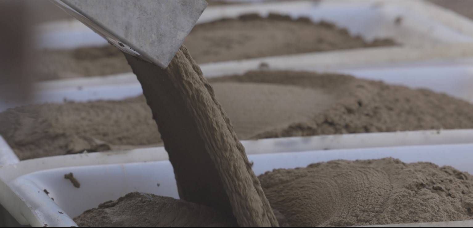 Concrete pouring from a chute into a wheelbarrow or mold