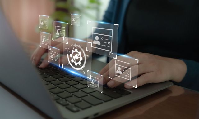 Person typing on laptop, overlaid with digital profile icons and settings gears.