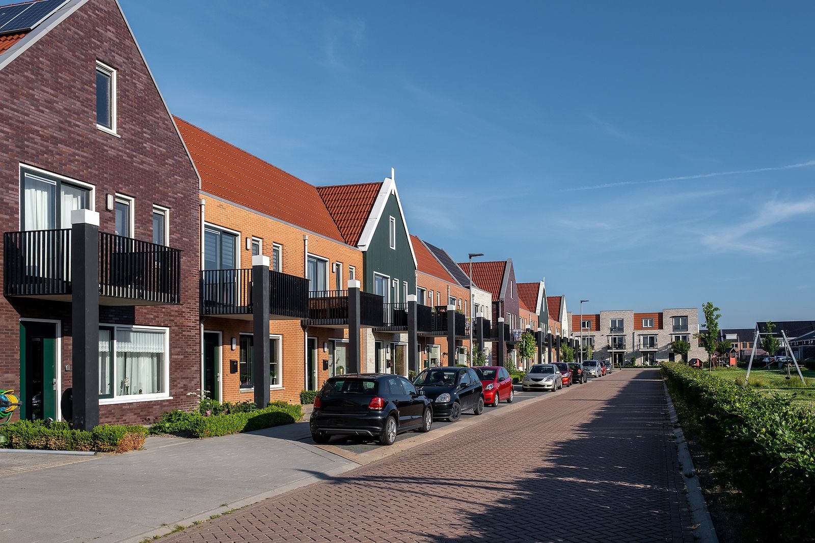 Een persoon gebruikt een balkzoeker op een witte muur vlakbij een deuropening in een woning.