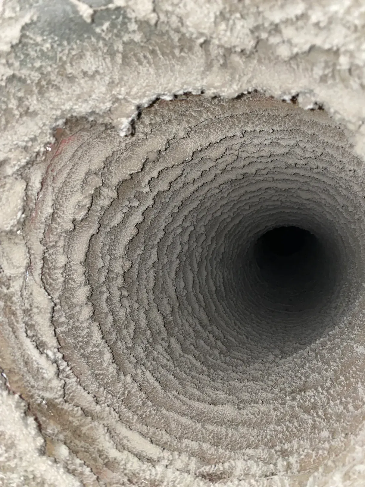 A close up of a dirty air vent with a hole in the middle.