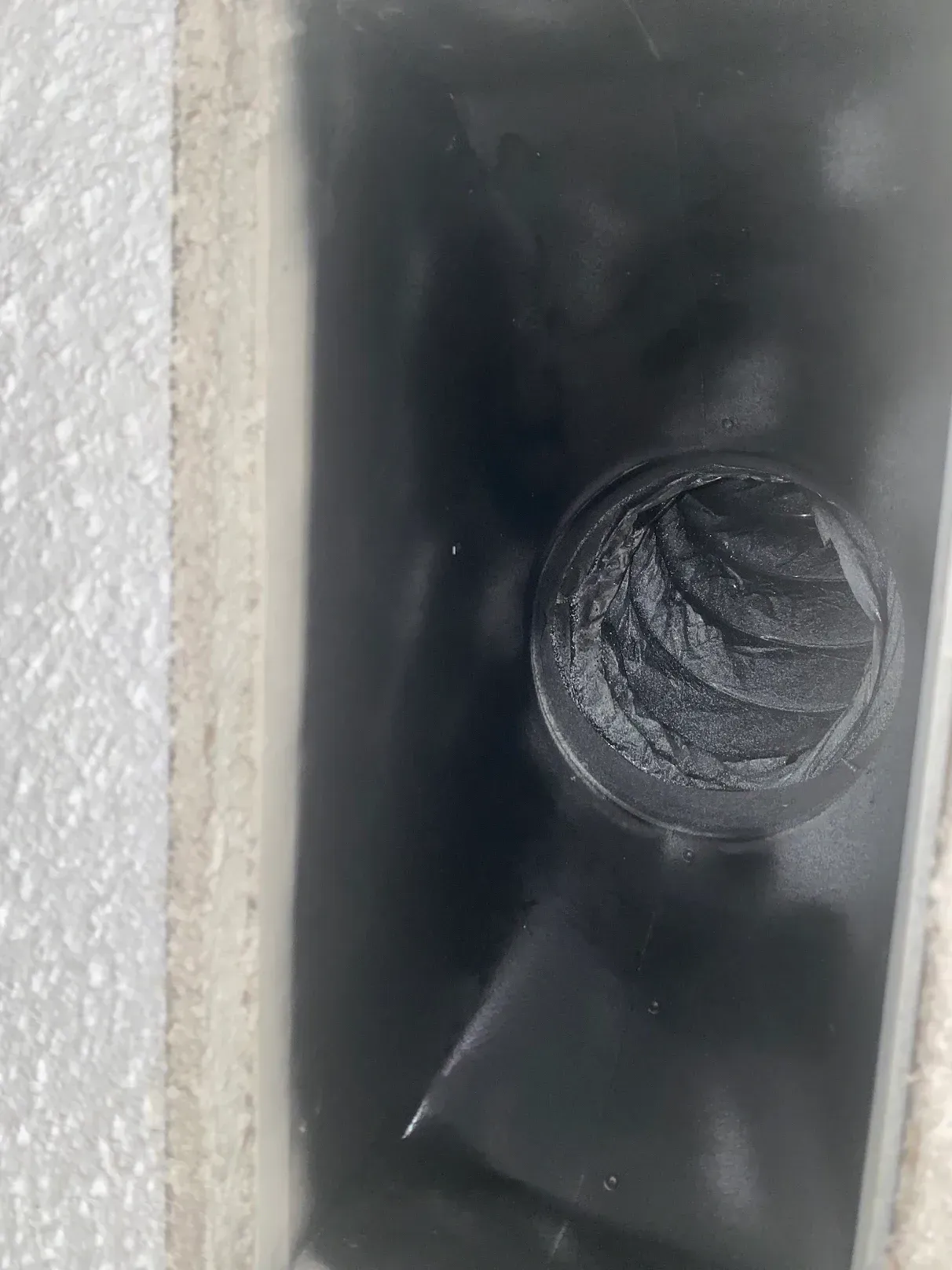 A close up of a black pipe with a hole in it.