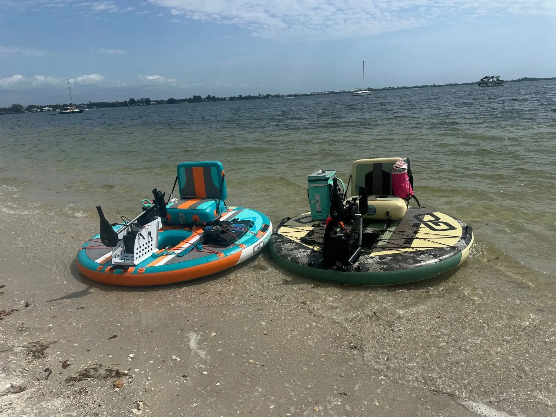 Two rafts are sitting on the beach near the water.