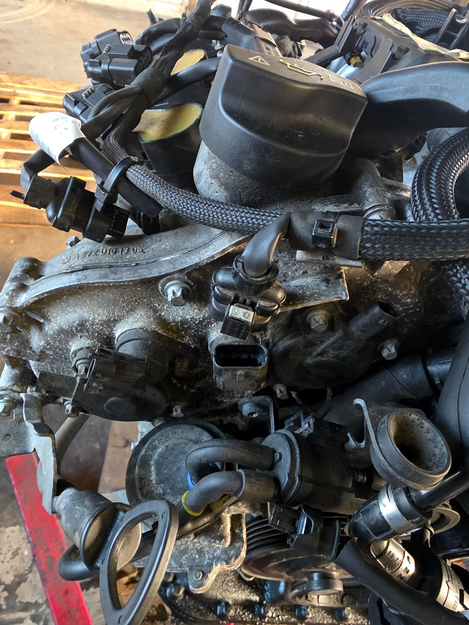 Cluttered pile of car engine parts in varying sizes and shapes. Gray metal and black plastic components. | Seth's Auto Care