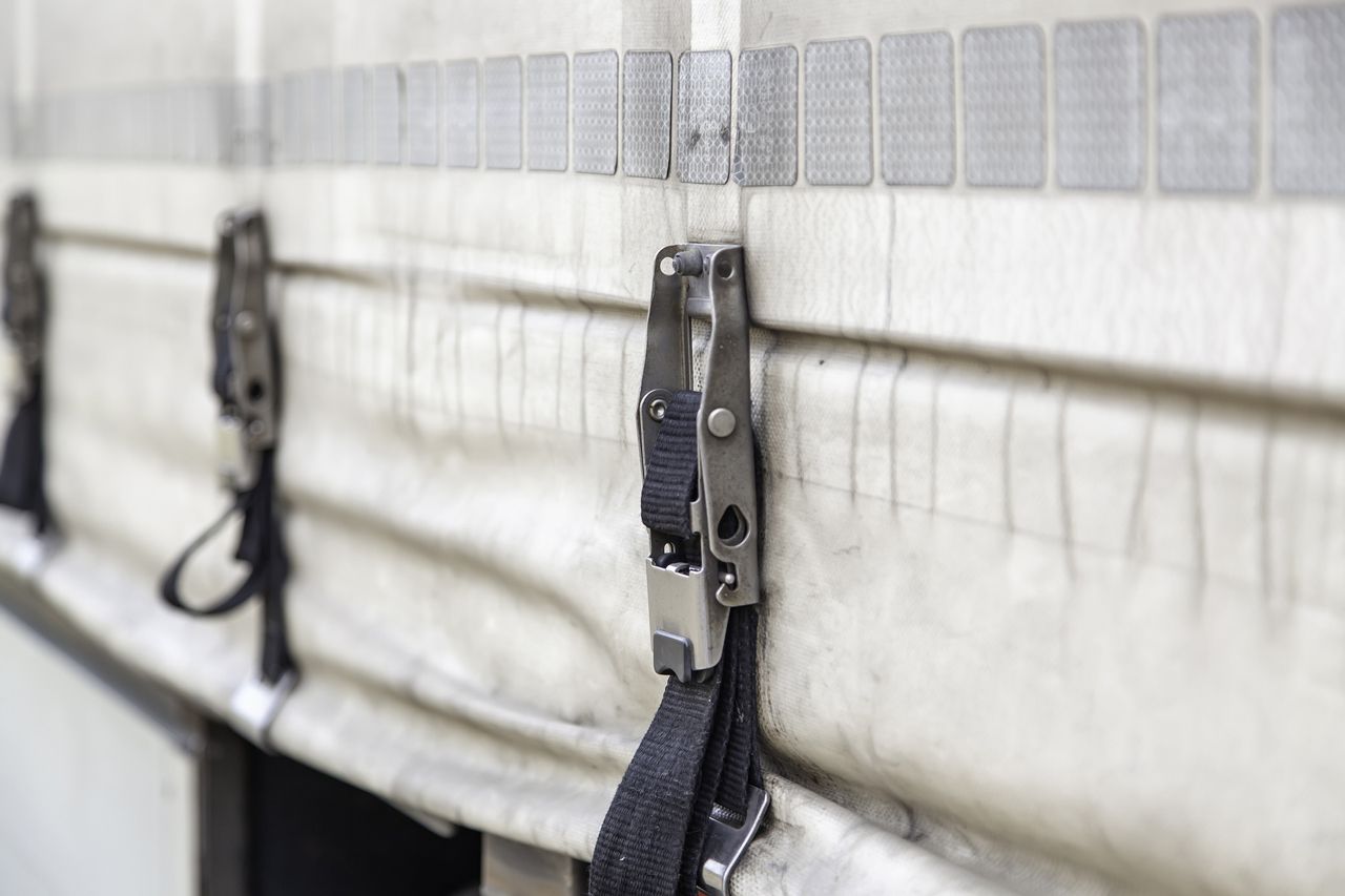A close up of a truck tarp with straps attached to it.