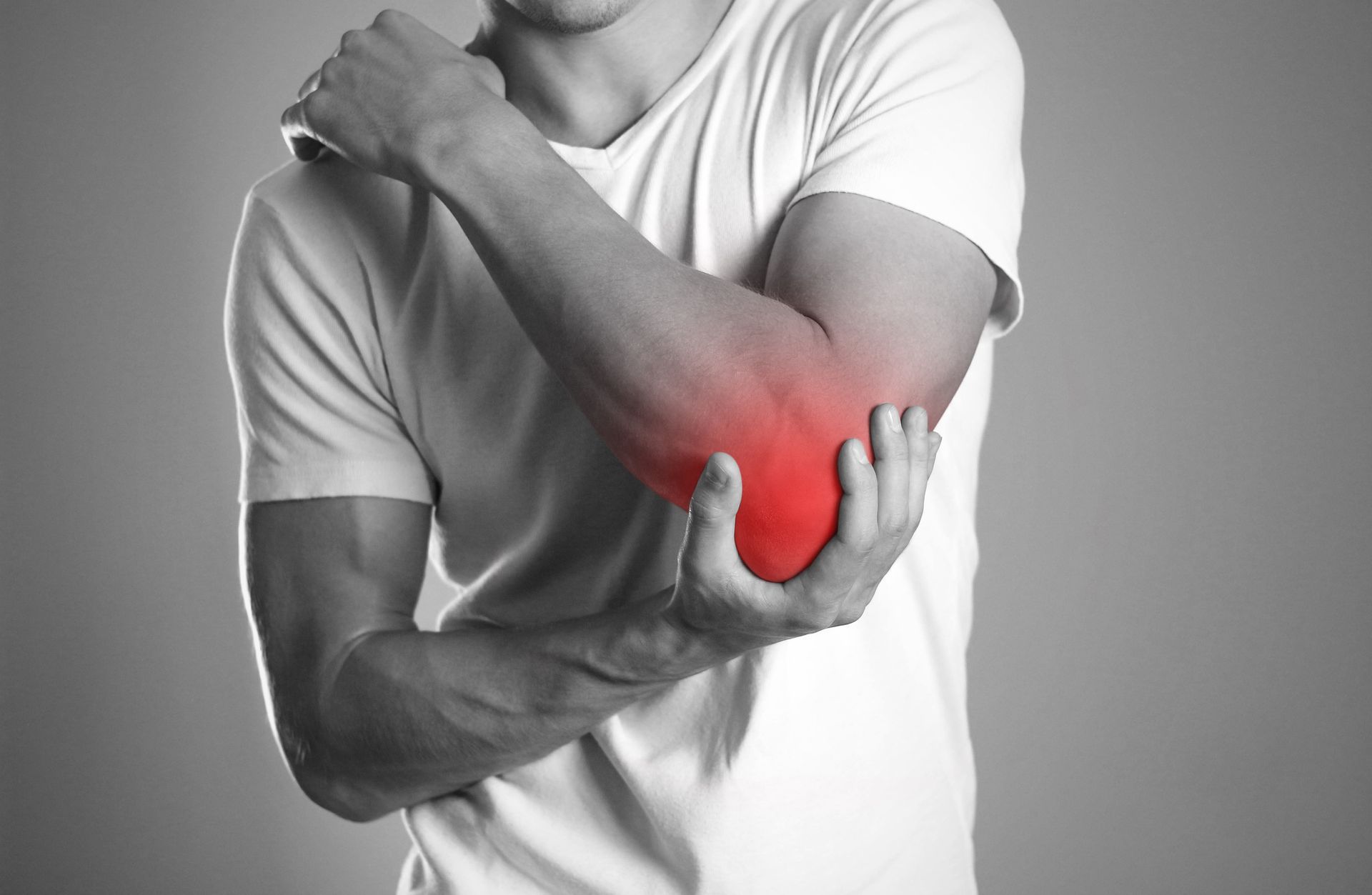 A man is holding his elbow in pain.