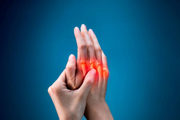 A person is holding their hand in pain.