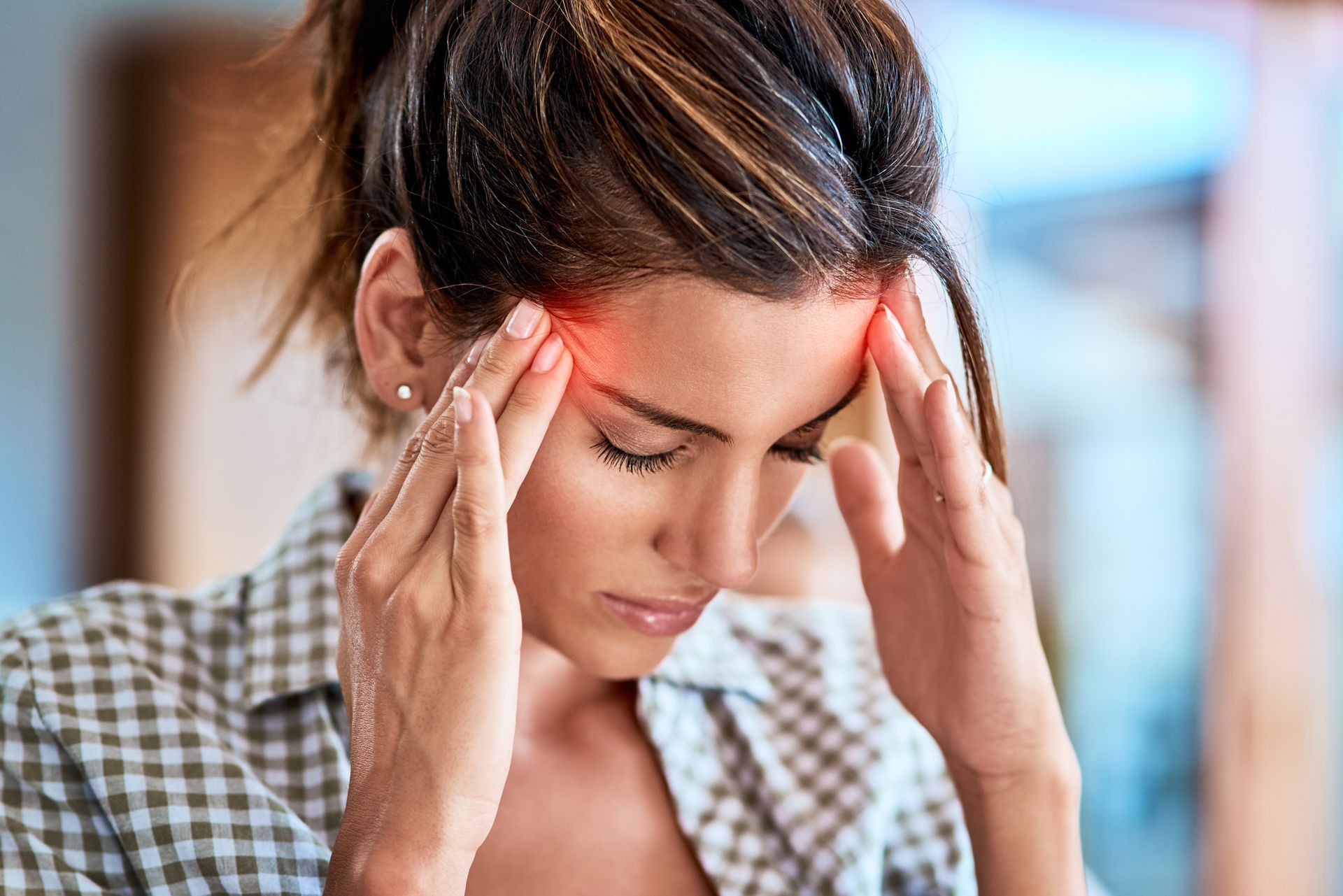 A woman is holding her head in pain because of a headache.