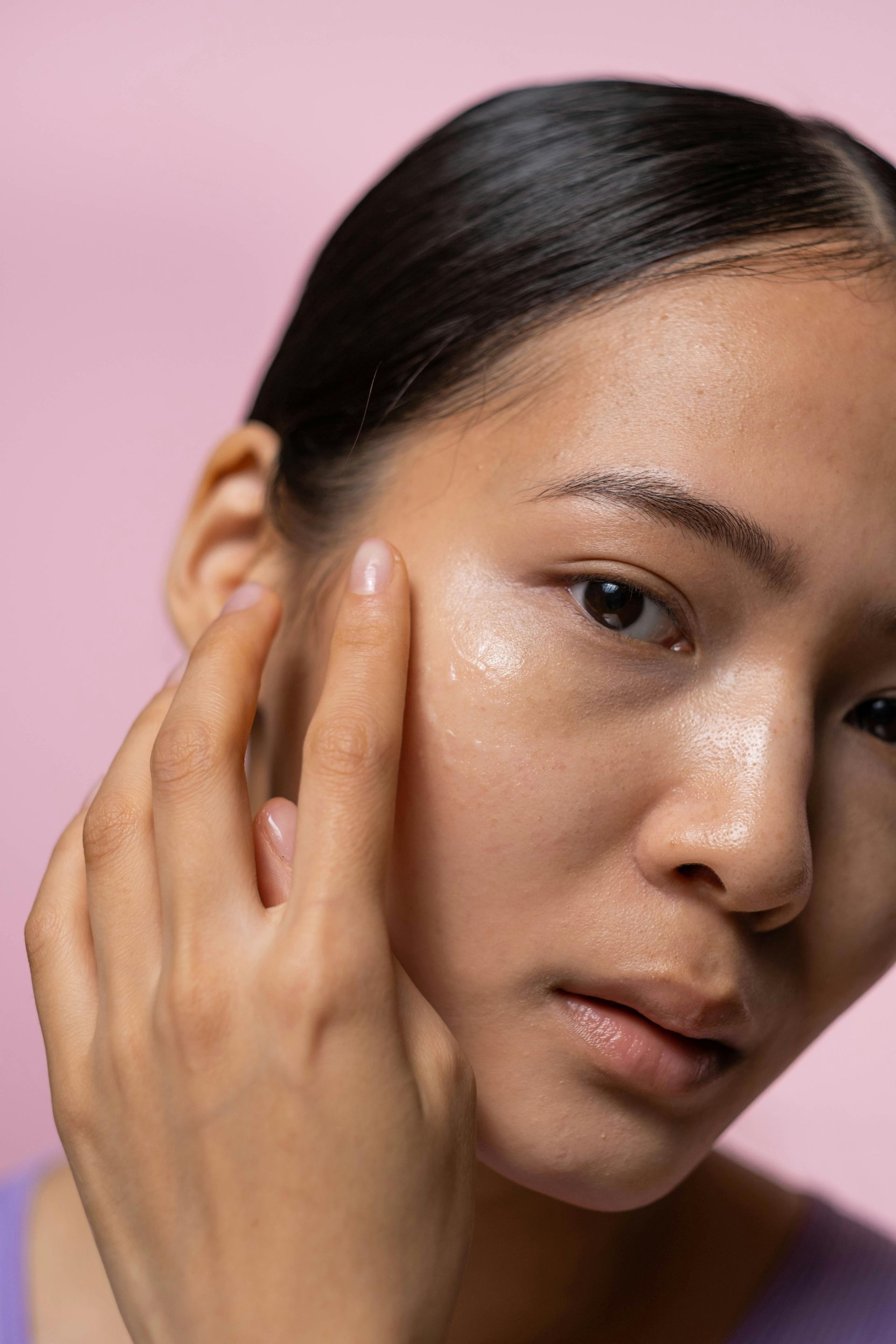 A close up of a woman 's face with her hand on it.