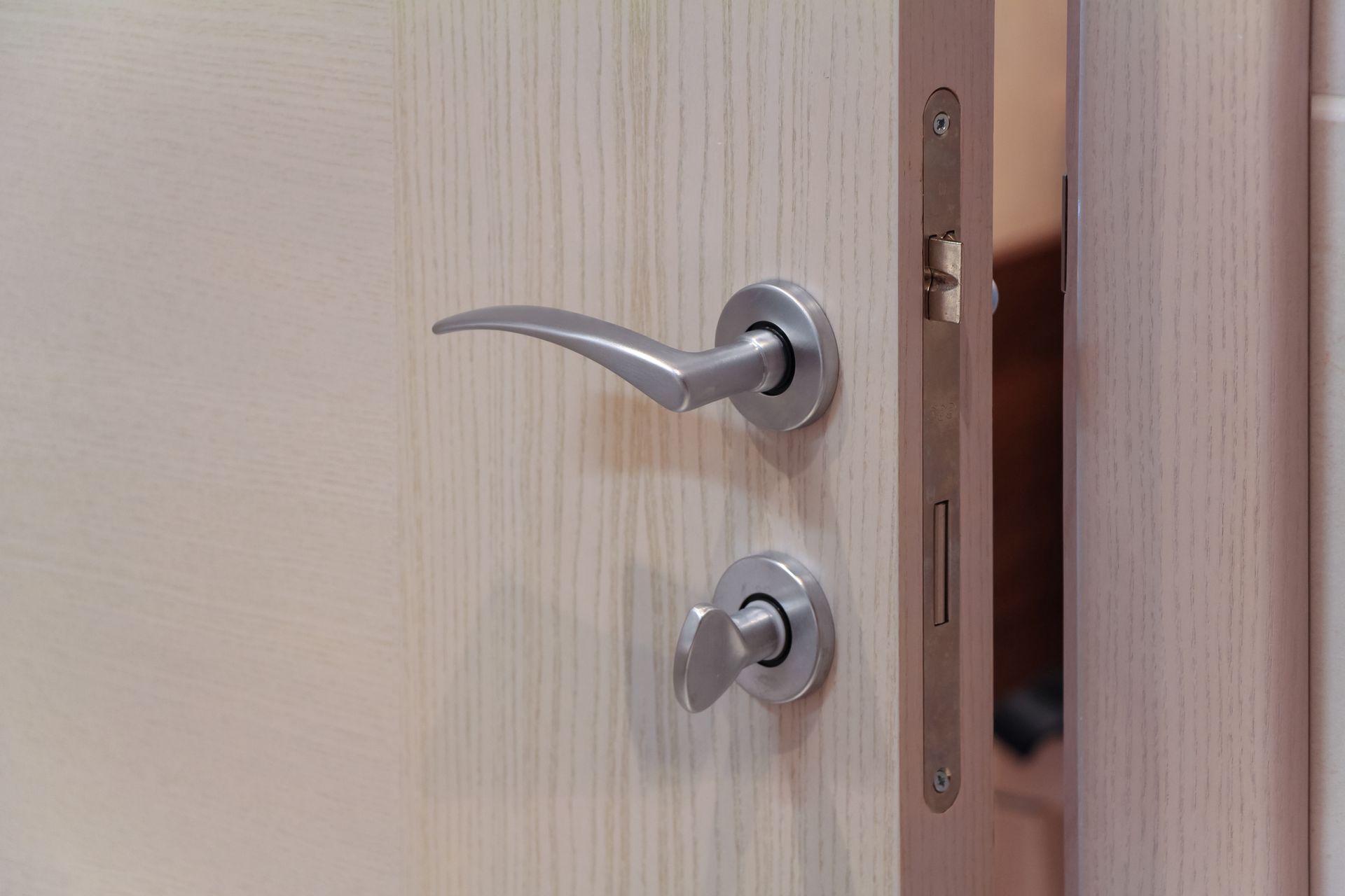 A close up of a door handle on a wooden door.